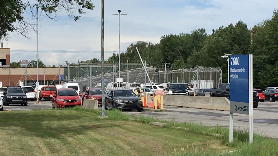 Le centre de détention de Trois-Rivières vue de face. En arrière-plan, un stationnement avec beaucoup de voitures. 