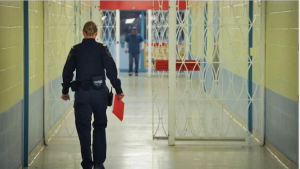 Un agent de sécurité marche dans le couloir d'un centre de détention.