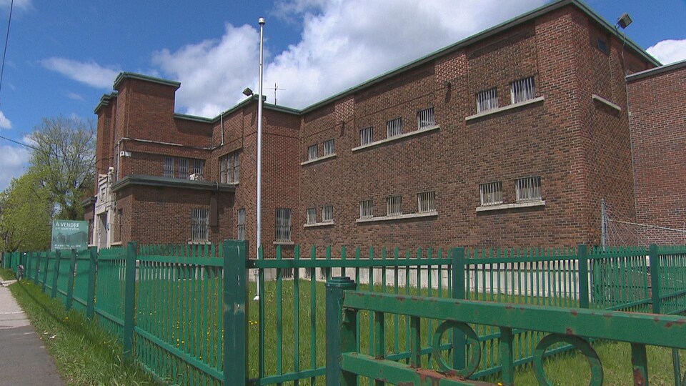 Une pancarte annonçant qu'une ancienne prison est à vendre est bien visible devant le bâtiment en question.