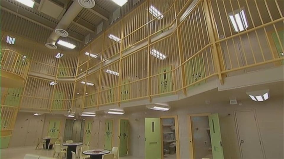 Une aire commune avec des tables à l'intérieur de la prison.