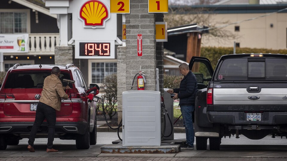 Des Britanno-Colombiens mettent de l'essence dans leur voiture. Le prix affiché à la pompe de 1,949 $. 