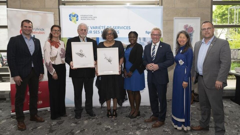 Quatre hommes et quatre femmes posent pour la photo.