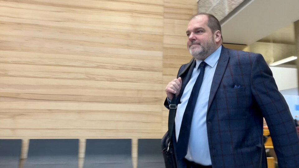 Harold LeBel se dirige vers la salle d'audience.