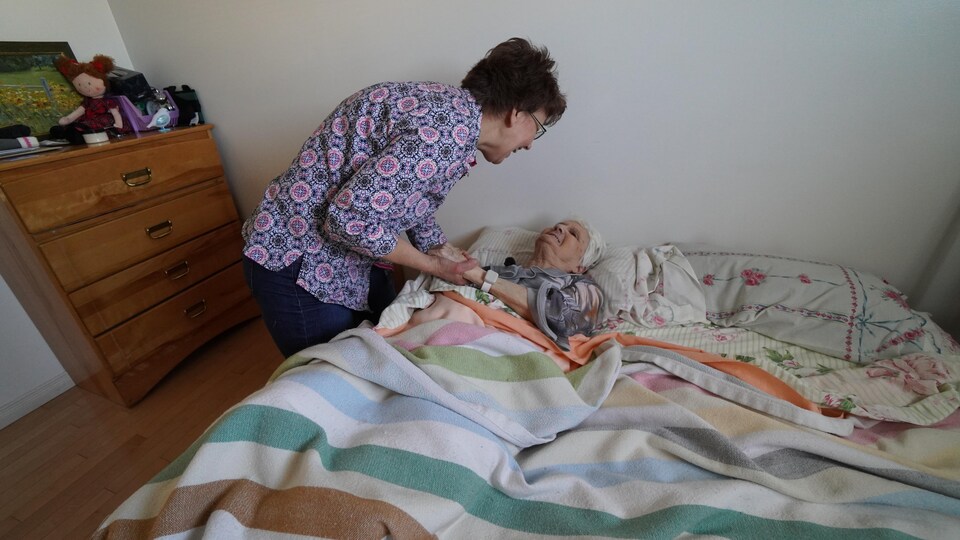 Sylvie Sylvestre aide sa mère à sortir du lit.