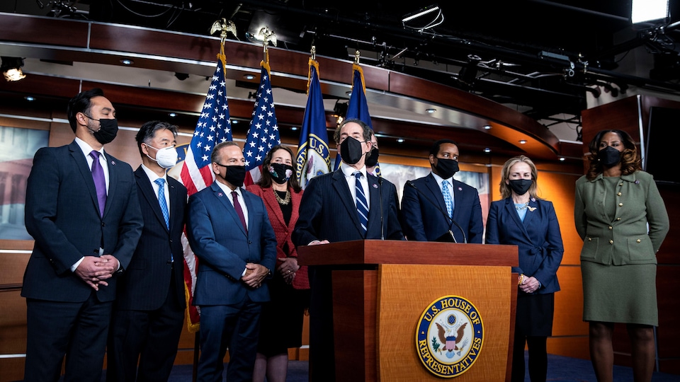 Jamie Raskin (au centre) et ses collègues de la mise en accusation, Joaquin Castro, Ted Lieu, David Cicilline, Diana DeGette, Eric Swalwell, Joe Neguse, Madeleine Dean et Stacey Plaskett, se sont adressés à la presse à la fin du procès, devant des drapeaux américains. 