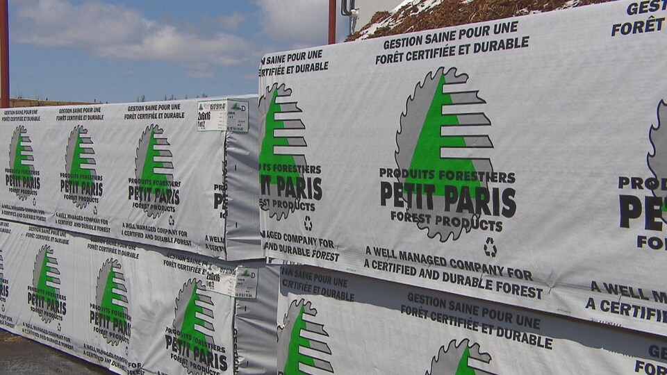 Des piles de bois empilées dans la cour de l'entreprise.