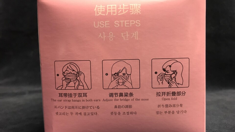 Une boite contenant des masques avec un étiquetage en chinois et en anglais.