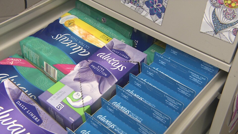 Des boîtes de serviettes hygiéniques et de tampons dans le tiroir d'un classeur.