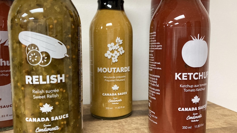 Des bouteilles sont placées les unes à côté des autres. La première contient de la relish, l'autre de la moutarde et la dernière du ketchup.