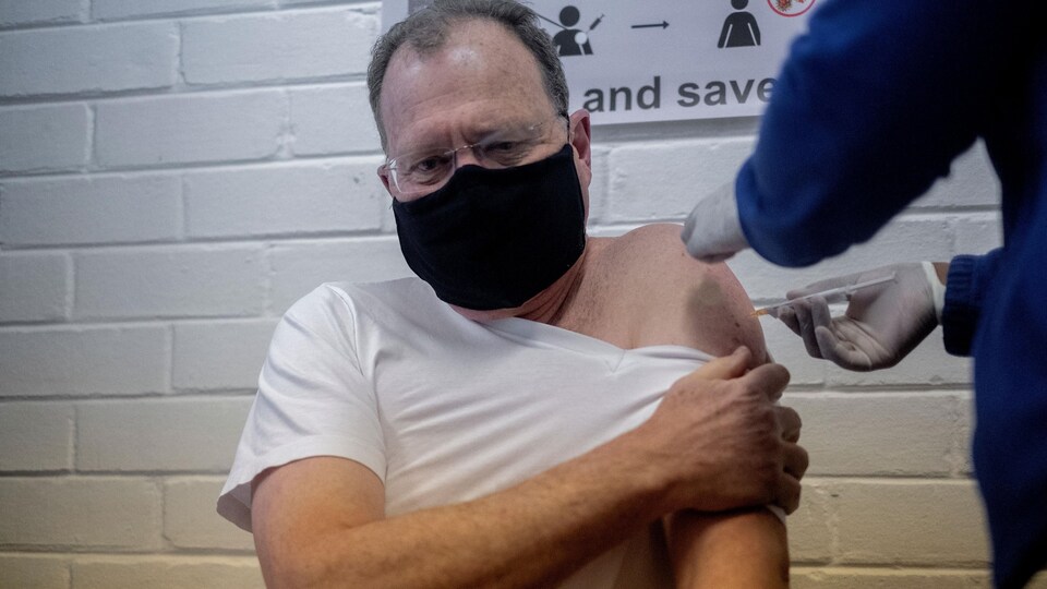 Martin Veller se fait injecter un vaccin dans l'épaule.