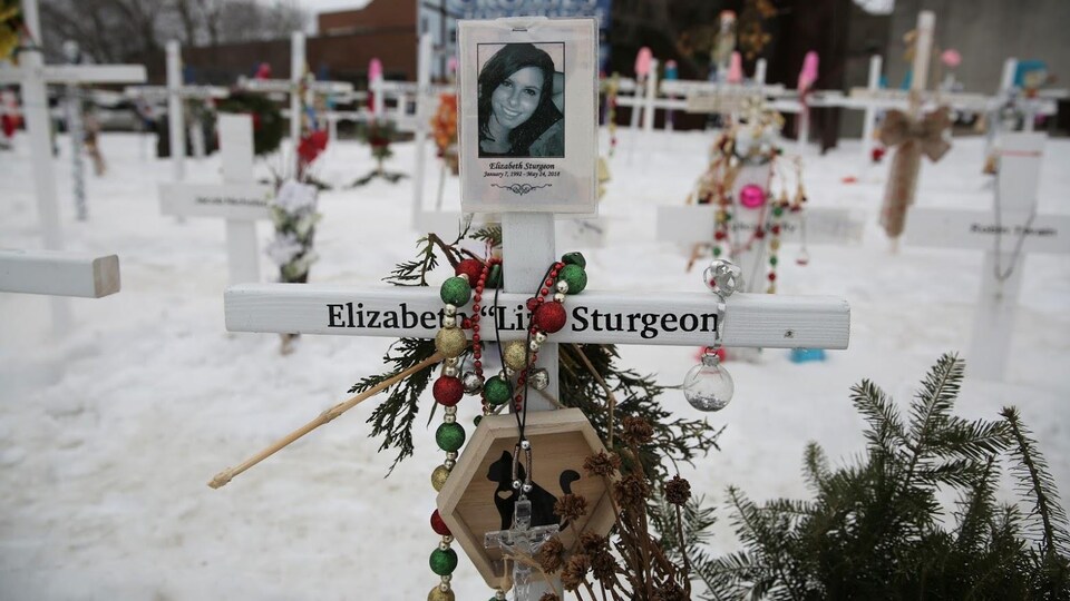 On peut voir le nom d'Elizabeth Sturgeon inscrit sur une croix blanche ornée de décorations et de sa photographie.