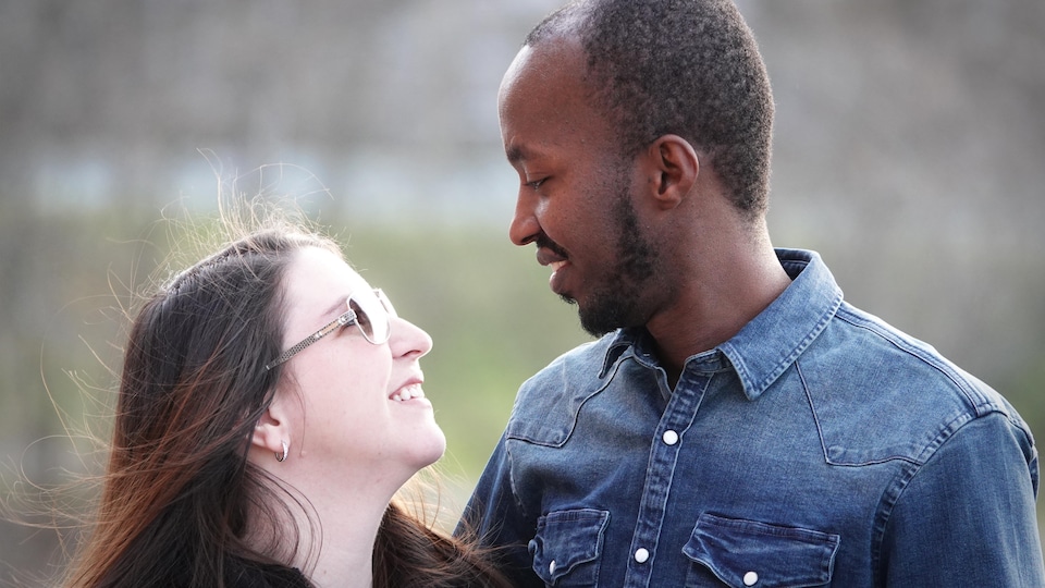 Un homme et une femme se regardent en souriant.