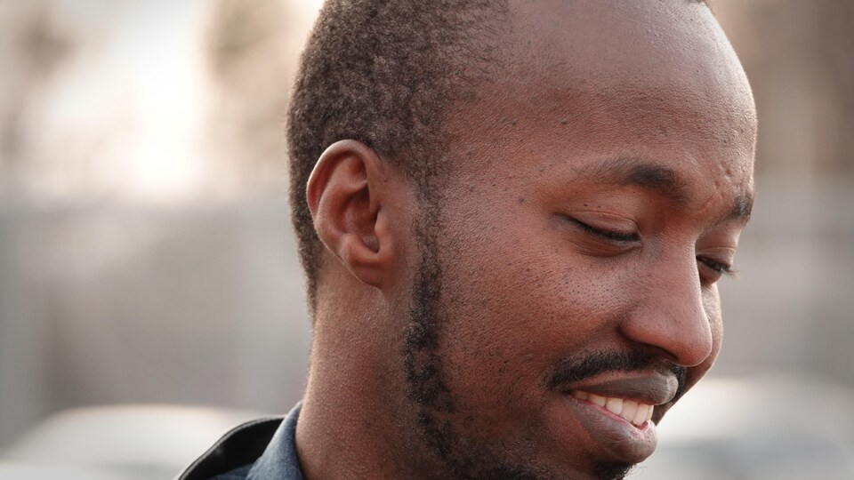 Un homme souriant de profil.