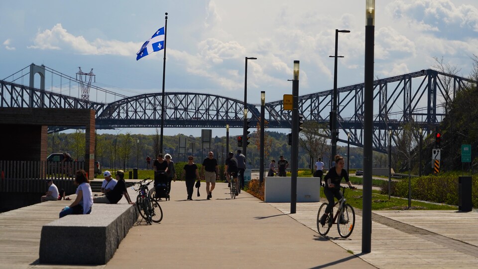 Des citoyens profitent du beau temps au quai des Cageux sur la promenade Samuel-De Champlain.