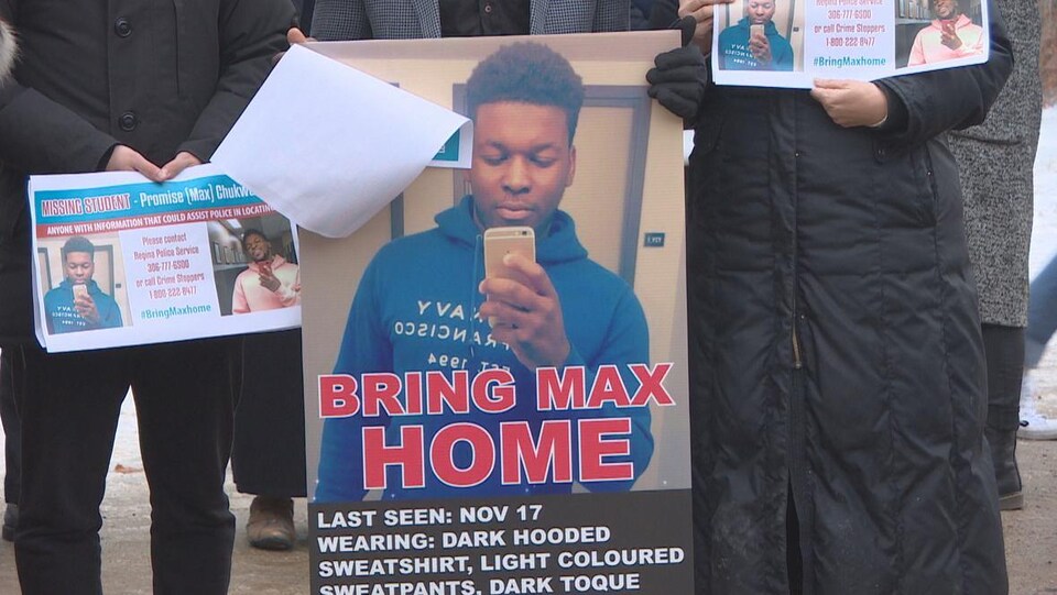 Des personnes tiennent des affichent de Promise « Max » Chuckwudum qui est porté disparu depuis le 17 novembre à Regina