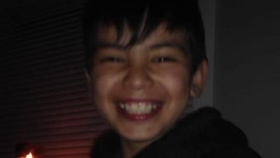 Visage d'un adolescent souriant à pleines dents.