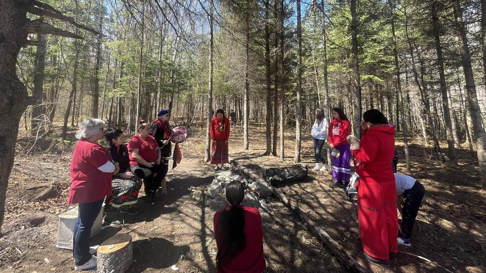 Des femmes autochtones participent à une cérémonie dans le bois. 
