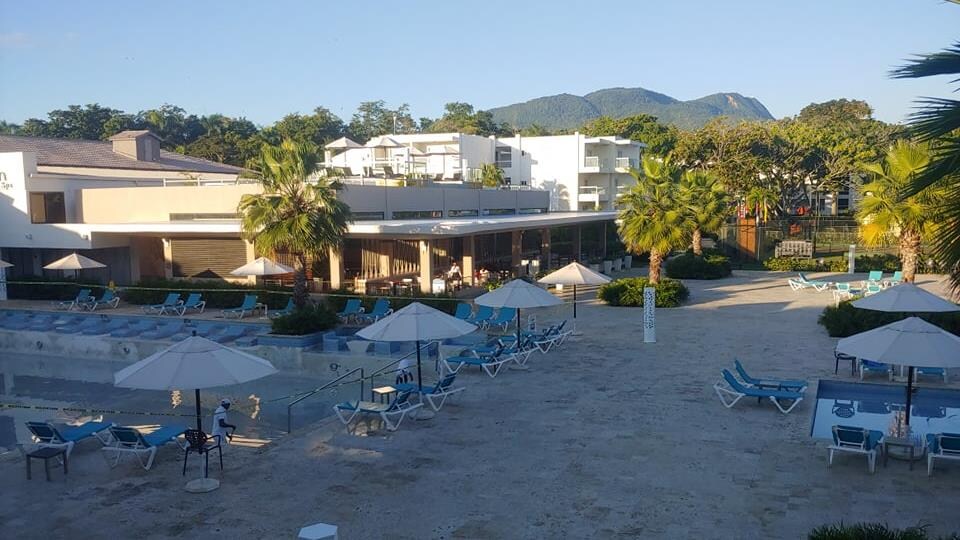 L'hôtel est bâti tout près de la plage, où sont installés des tables et des parasols.