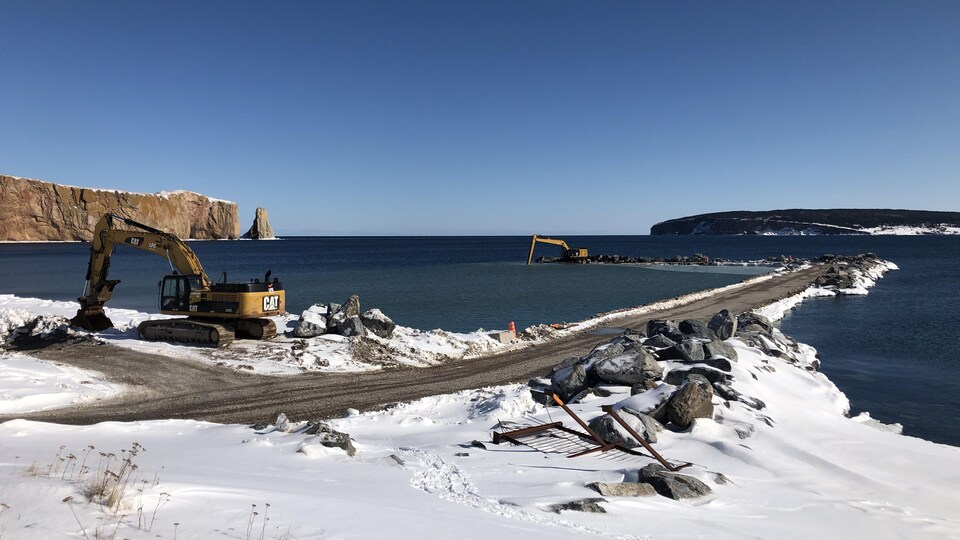 Des travaux aux abords d'un quai et sur le quai devant le rocher Percé