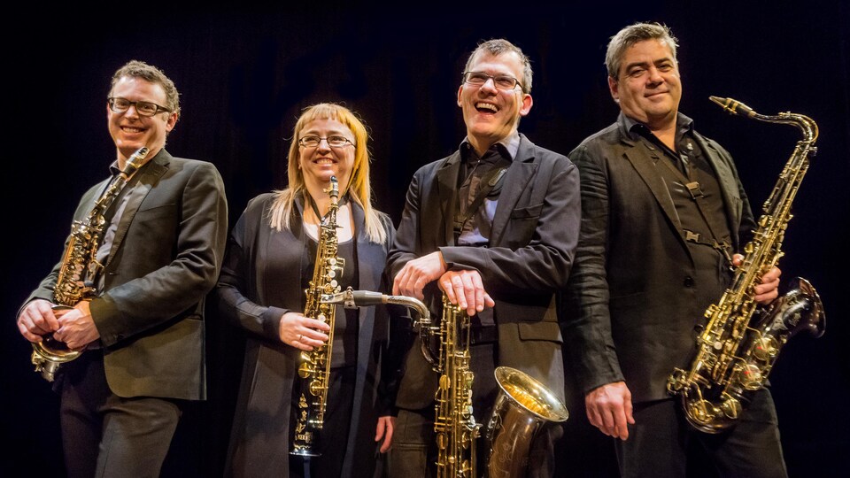 Quatre saxophonistes qui tiennent leur instrument dans les mains