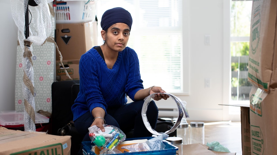 Une jeune femme sikhe vide des boîtes.