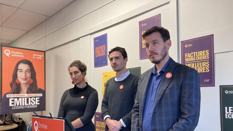 Émilise Lessard-Therrien, Alexis Lapierre et Benjamin Gingras sont entourés de pancartes électorales de Québec solidaire.