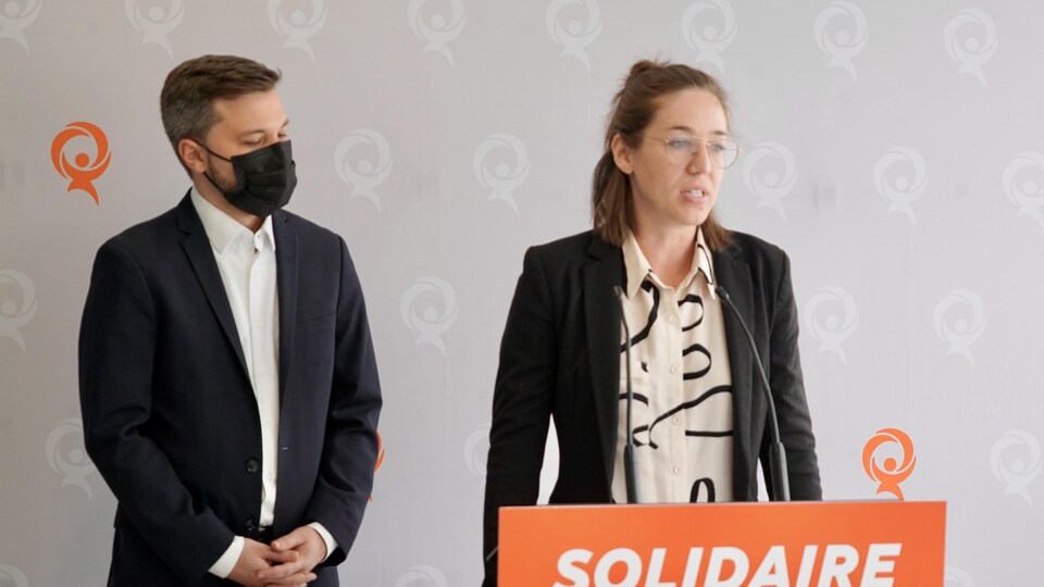 Québec Solidaire candidate Carol-Ann Kack speaks behind a table at Rimouski station.  He was accompanied by party spokesman Gabriel Nadeau-Dubois. 