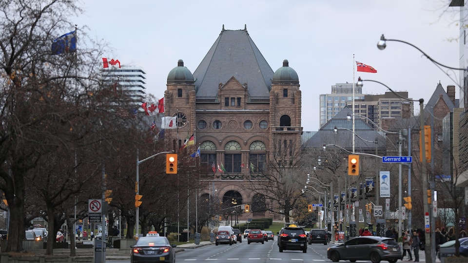 Le bâtiment du parlement ontarien de Queen's Park avec vue sur une rue de Toronto.
