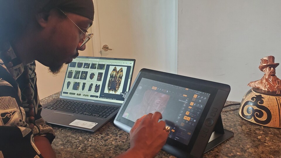 L'artiste travaillant devant l'écran d'une tablette.