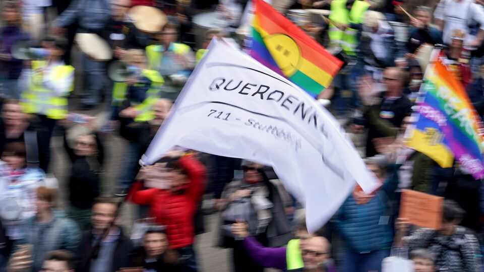 Des gens brandissent des drapeaux et des porte-voix lors d'une manifestation en Allemagne.
