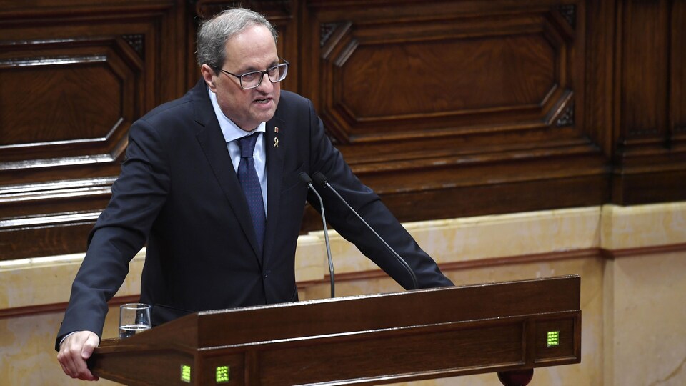 Quim Torra se tient derrière un lutrin et prend la parole au Parlement à Barcelone, le 17 octobre 2019.