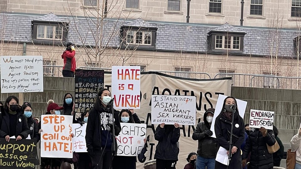 Des manifestants arborent des pancartes appelant à cesser les actes racistes et les violences envers les personnes d'origine asiatique. 