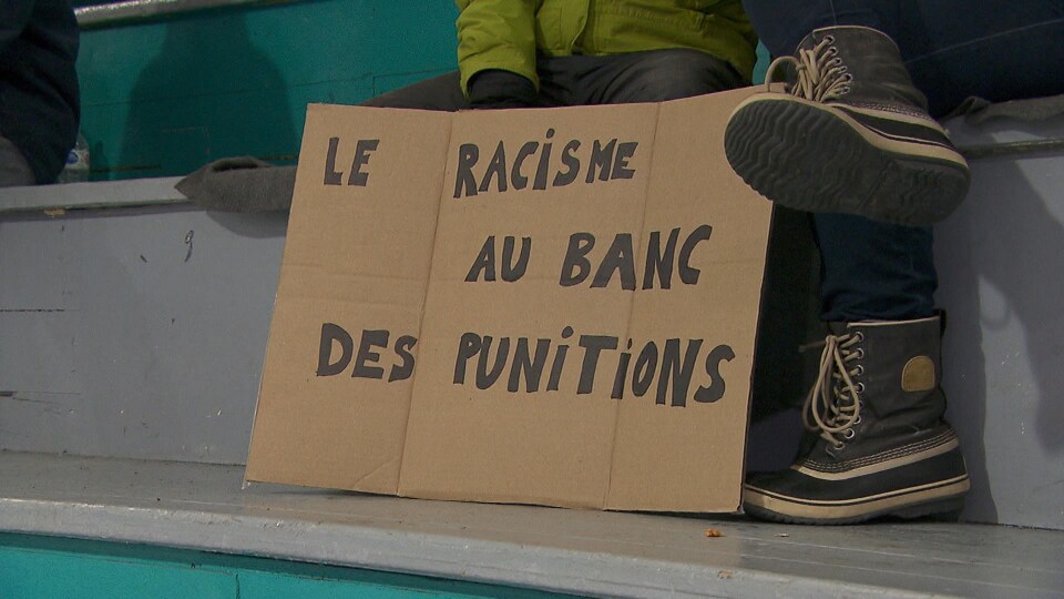 Une pancarte qui dénonce le racisme dans les arénas, au match antiracisme de Gesgapegiag.