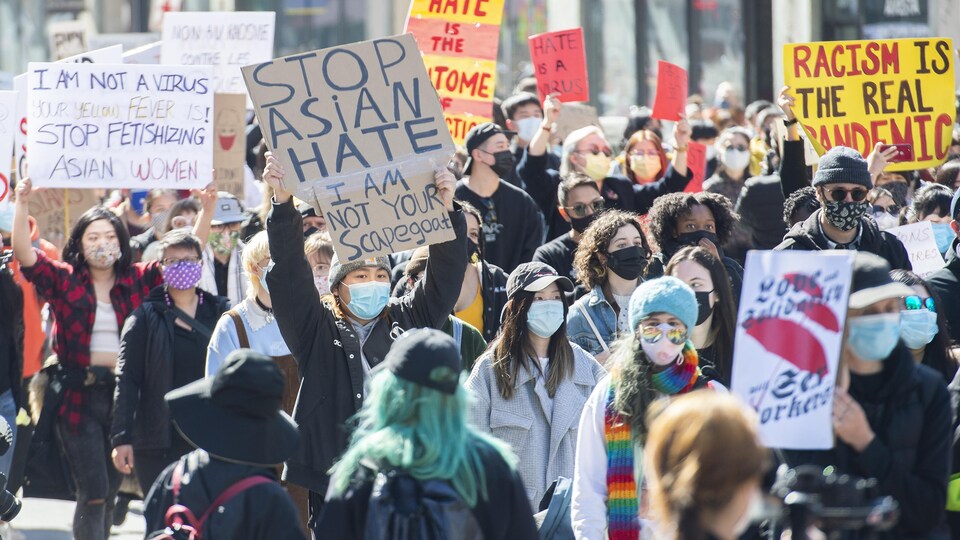 Des manifestants portent des pancartes.