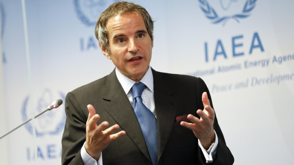 Rafael Mariano Grossi en conférence de presse devant le logo de l'AIEA.