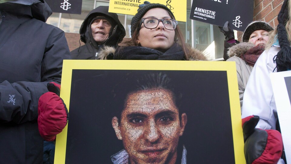 Ensaf Haidar, l'épouse de Raif Badawi tient une pancarte avec sa photo. 
