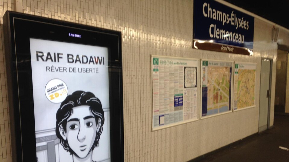 Un écran numérique avec un dessin de Raif Badawi à la gare des Champs-Élysées.