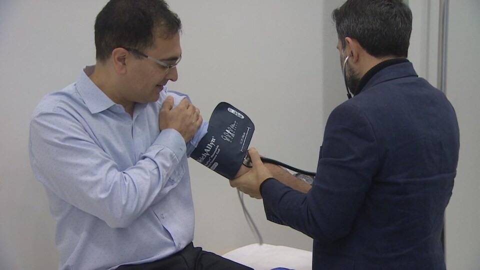 Un homme de dos prend la tension artérielle du Dr Raj Attariwala.