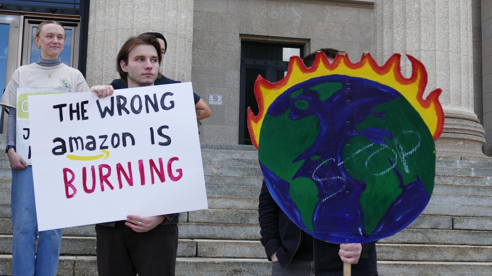 Des jeunes brandissent des pancartes affirmant que la planète brûle.