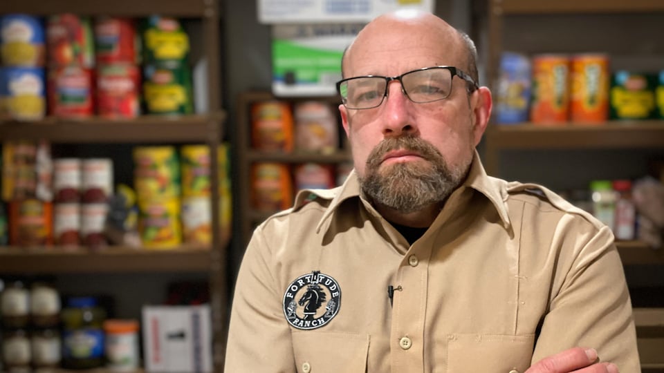Un homme se tient debout dans le garde-manger de son bunker.
