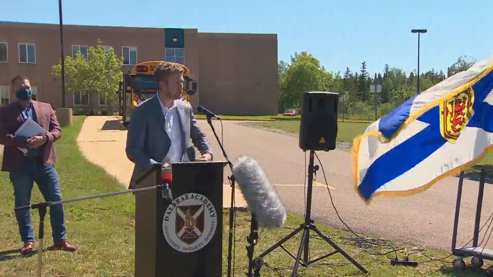 Iain Rankin donne une conférence de presse devant l'école.