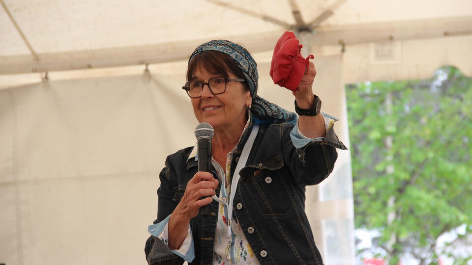 Anne Panasuk tient des mocassins d'enfant rouges.