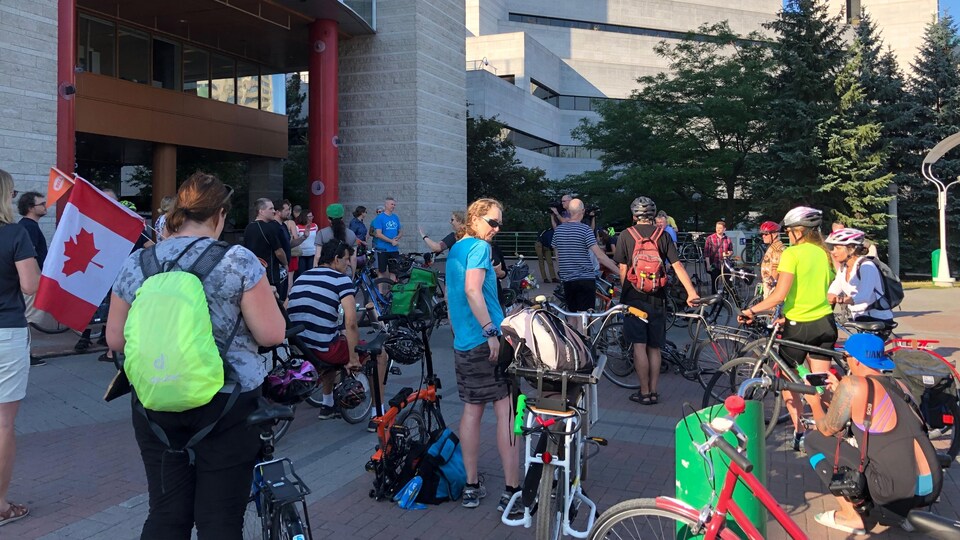 Des cyclistes se rassemblent devant l'hôtel de ville.