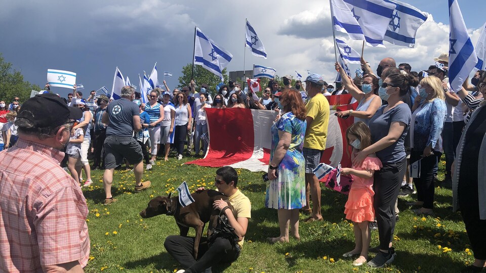 Des personnes rassemblées arborent des drapeaux israéliens.