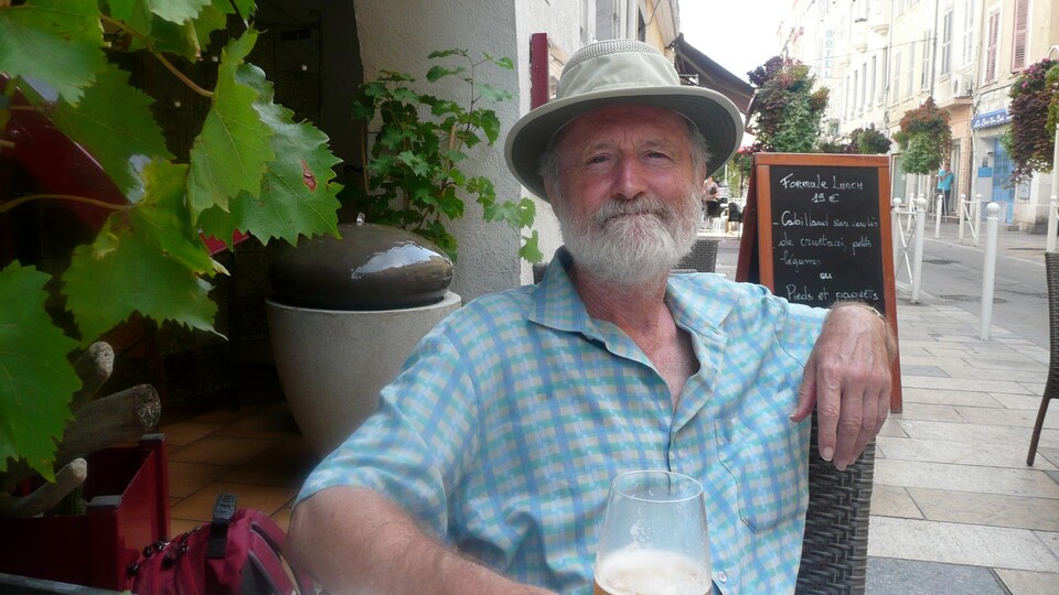 Raymond Bradley boit une bière sur une terrasse.