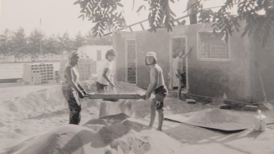 Young people are building a house, black and white photo. 