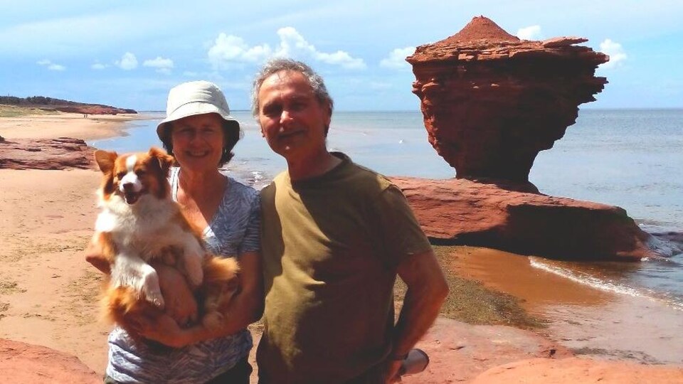Raynald Charest et son épouse Marie Brien à la plage. Marie tient une chienne dans ses bras.