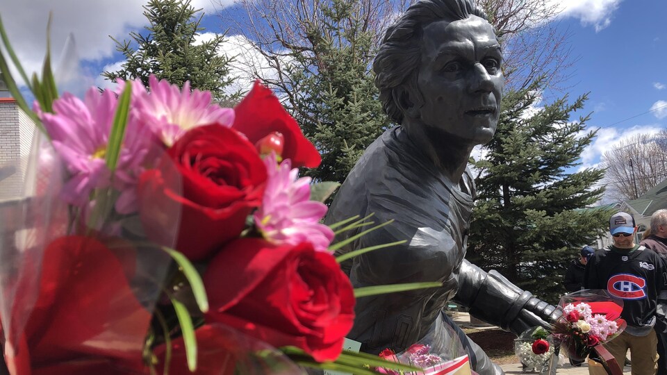 Une statue de Guy Lafleur recouverte de fleurs.