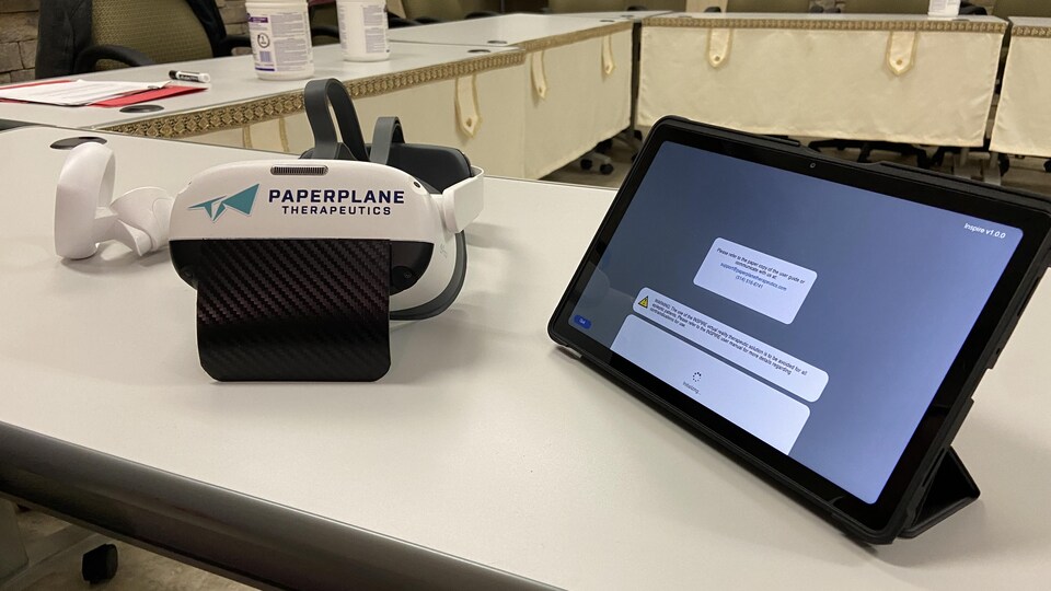 Un casque de réalité et une tablette sur une table.