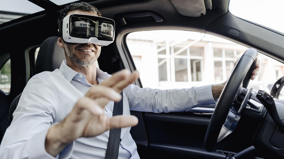 Un homme d'affaires portant un casque de réalité virtuelle en voiture